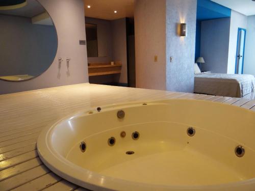 a bath tub sitting on a wooden floor in a room at Diamond Hotel in Rio de Janeiro