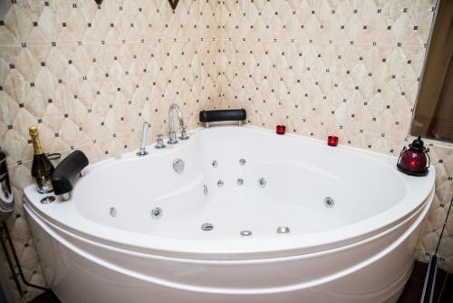 a white bath tub in a bathroom with tiles at SPA Hotel Medicus in Varshets