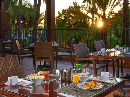a table with food and drinks on a patio at Ria Park Hotel & Spa in Vale do Lobo