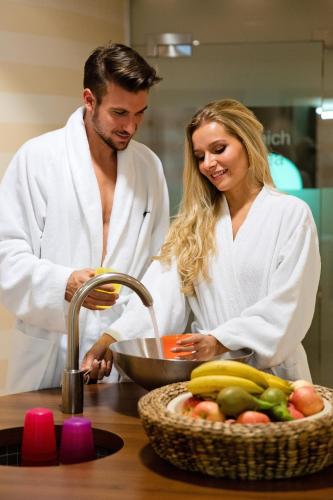a man and woman standing in a kitchen preparing food at Hotel Zum Mohren in Reutte