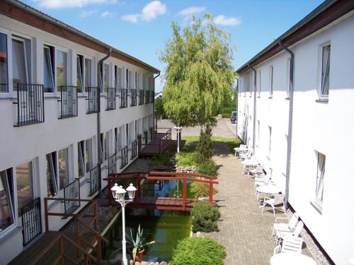 einen leeren Innenhof eines Gebäudes mit Tischen und Stühlen in der Unterkunft Hotel Rügen Park KG in Gingst