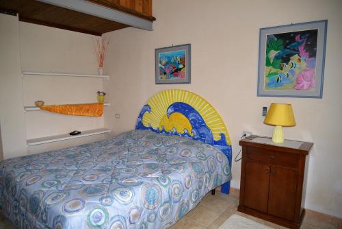 a bedroom with a bed and a table with a lamp at Hotel Valle del Cedrino in Galtellì