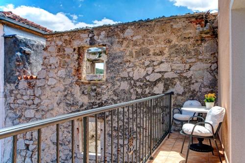 a balcony with a stone wall and two chairs at Hotel Skradinski Buk in Skradin