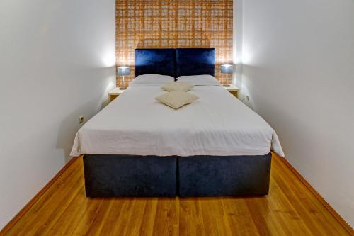 a bedroom with a large bed with a blue headboard at Hotel Skradinski Buk in Skradin