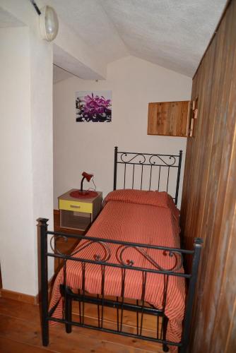 a bedroom with a bed with a red comforter at Hotel Valle del Cedrino in Galtellì