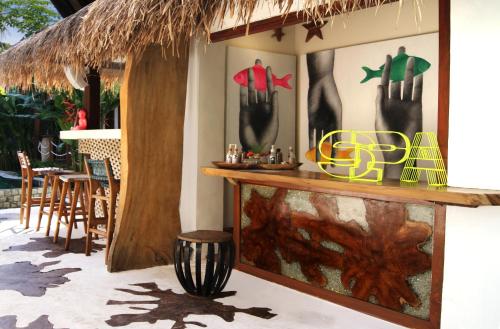 a bar in a restaurant with a table and chairs at Kaleydo Villas in Gili Trawangan