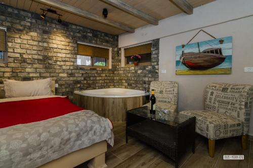 - une chambre avec une baignoire, un lit et une chaise dans l'établissement Dream Cabin, à Tibériade