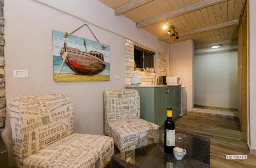 salon z 2 krzesłami i butelką wina w obiekcie Dream Cabin w mieście Tyberiada