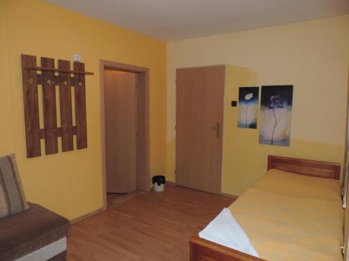 a bedroom with a bed and a room with yellow walls at Western Penzion in Ružomberok