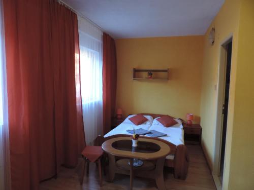 a small room with a bed and a table at Western Penzion in Ružomberok