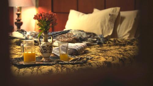 a tray with two glasses of orange juice and flowers on a bed at La Casa del Atrio in Querétaro