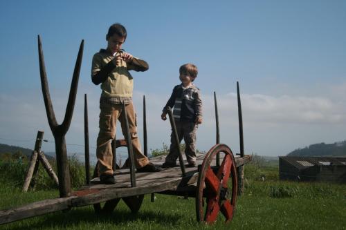 two boys are standing on a wooden bridge at Hotel Rural Casona Trabadelo in Vegadeo