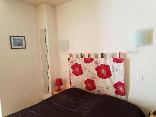 a bedroom with a bed with a red and white pillow at Hôtel Des Poètes avec parking sur réservation in Béziers