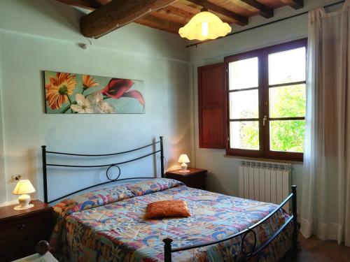 a bedroom with a bed and two windows at Apartments Borgo Toscano in Gambassi Terme