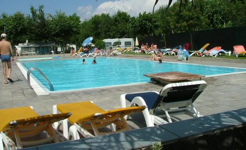basen z krzesłami i ludzie pływający w nim w obiekcie Campeggio Amici di Lazise w mieście Lazise