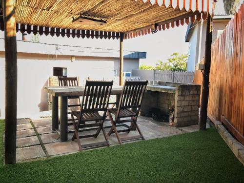 a table and two chairs under a pergola at Take a Break Self Catering Accommodation in Knysna