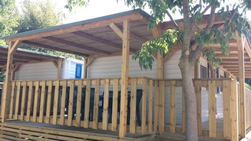 a wooden pergola on a house with a tree at Campeggio Amici di Lazise in Lazise