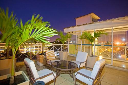 un patio con sedie e un tavolo sul balcone. di Hotel Cantareira a Niterói