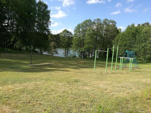 a park with two swings and a goal at Likimo ratas in Paliepis