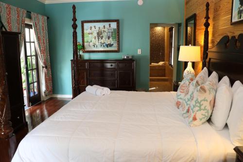 a bedroom with a large white bed with blue walls at La Te Da - Adult Only, 21 or older in Key West