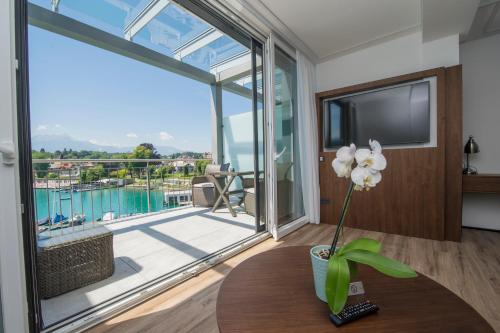 a living room with a table and a large window at Boutiquehotel Wörthersee - Serviced Apartments in Velden am Wörthersee