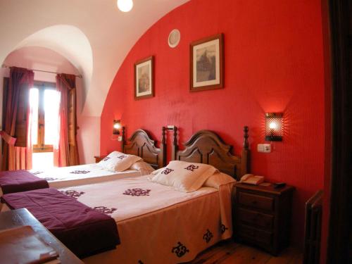a red bedroom with two beds and a window at La Posada de Carmen in Chañe
