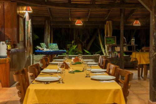 a long table in a restaurant with yellow table cloth at Tiskita Jungle Lodge in Pavones