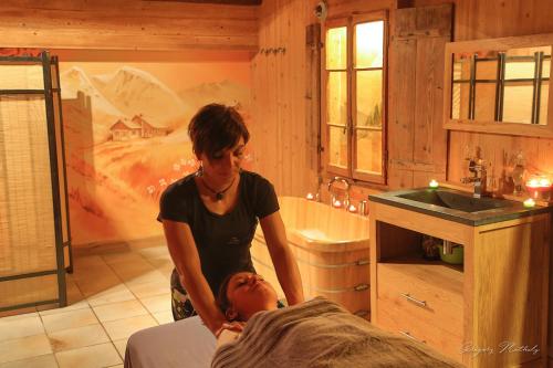 een vrouw die naast een vrouw staat in een badkamer bij Hotel L'Equipe in Morzine