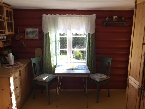 einen Tisch und Stühle in einer Küche mit Fenster in der Unterkunft Løngdal in Tuddal