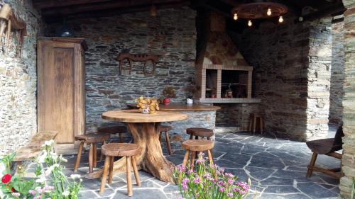 a patio with a wooden table and stools at Apartamentos Los Castros in San Tirso de Abres