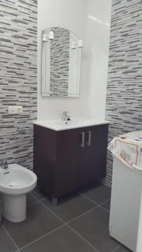 a bathroom with a sink and a toilet and a mirror at VV Paraíso Del Sur in Playa Paraiso