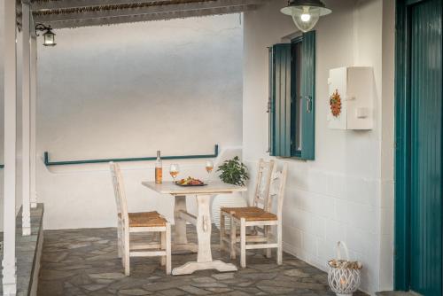 a table with two chairs and a bottle of wine at Mandrakia Bliss House in Mandrakia