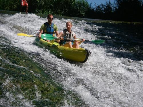 a man and a woman in a kayak on a river at Coté piscine Villa plain pied in Alignan-du-Vent
