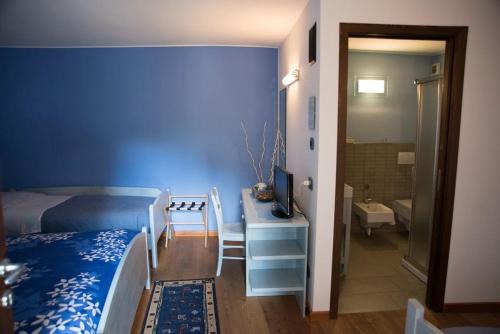 a bedroom with a bed and a desk with a television at B&B La Maison D' Amelie Camere e Appartamenti in Fenis