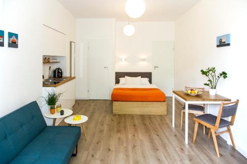 Zimmer mit einem Bett, einem Sofa und einem Tisch in der Unterkunft Garden Studio in Krakau