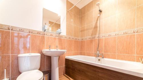 a bathroom with a toilet and a sink and a bath tub at Victorian Apartment in Bournemouth