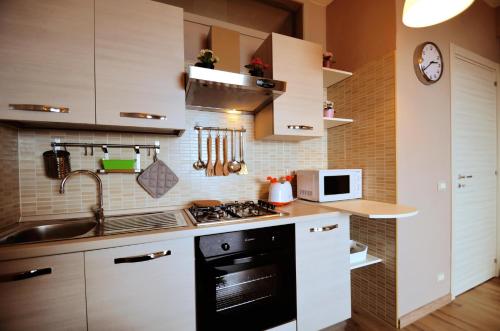 a kitchen with white cabinets and a stove top oven at Casa Antonella in Letojanni