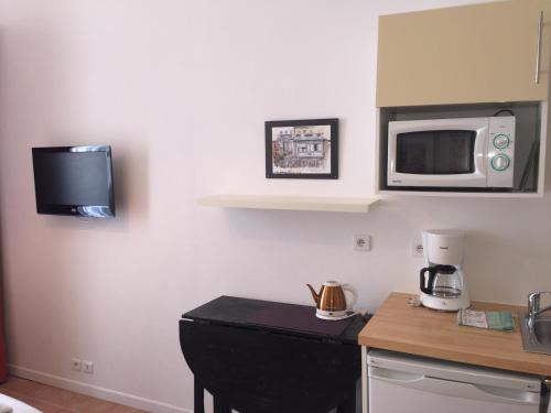 a kitchen with a counter and a microwave on the wall at Studios Floreal in Nice