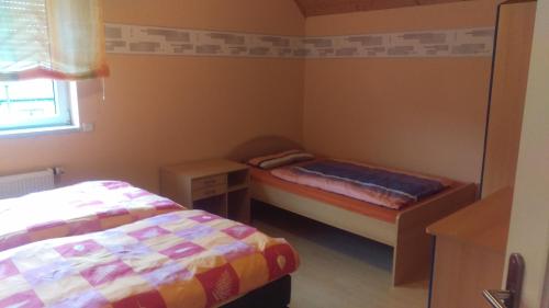 a small bedroom with two beds and a window at Ferienhaus Bornscheuer in Gerstungen