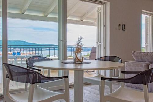 uma mesa e cadeiras numa sala de estar com uma varanda em Salt & Sand Villa em Kornić
