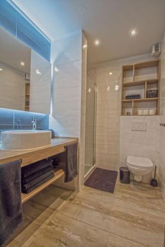 a bathroom with a sink and a toilet at Salt & Sand Villa with a view in Kornić