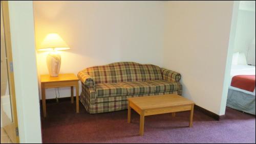 a living room with a couch and a table with a lamp at Peppermill Empress Inn in Centralia