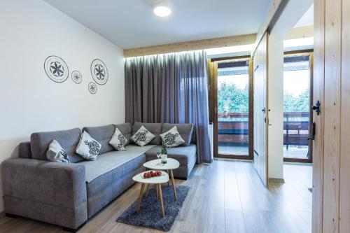 a living room with a couch and a table at Willa Baciarka-basen, sauny i jacuzzi in Kościelisko