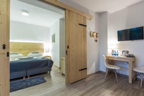 a bedroom with a bed and a desk with a computer at Willa Baciarka-basen, sauny i jacuzzi in Kościelisko
