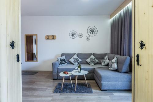 a living room with a couch and a table at Willa Baciarka-basen, sauny i jacuzzi in Kościelisko