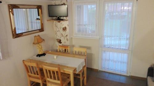 a dining room with a table and chairs and a television at Agroturystyka Kwatery pracownicze Noclegi Rybno Mazury in Rybno