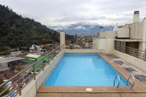a swimming pool on top of a building with a mountain at Departamento Santiago Centro in Santiago