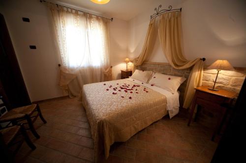 a bedroom with a bed with red roses on it at Agriturismo La Spiga D'Oro in Frontino