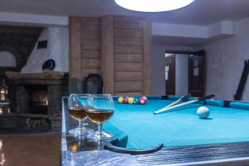 two glasses of wine sitting on a pool table at Willa Baciarka-basen, sauny i jacuzzi in Kościelisko