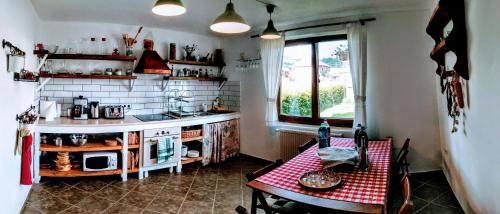 ソバタにあるCasa cu Aburi Sovataのカウンターとテーブル付きのキッチン、窓